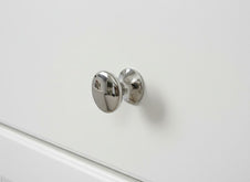 Chrome cabinet knob on a white drawer